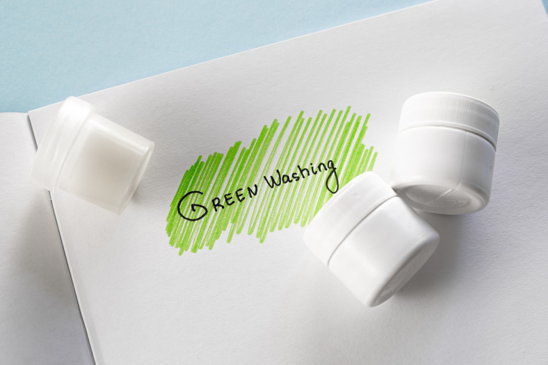 Greenwashing concept. Drawing on paper with text and green marker strokes. Environmental marketing disinformation. Non transparent green sheen.